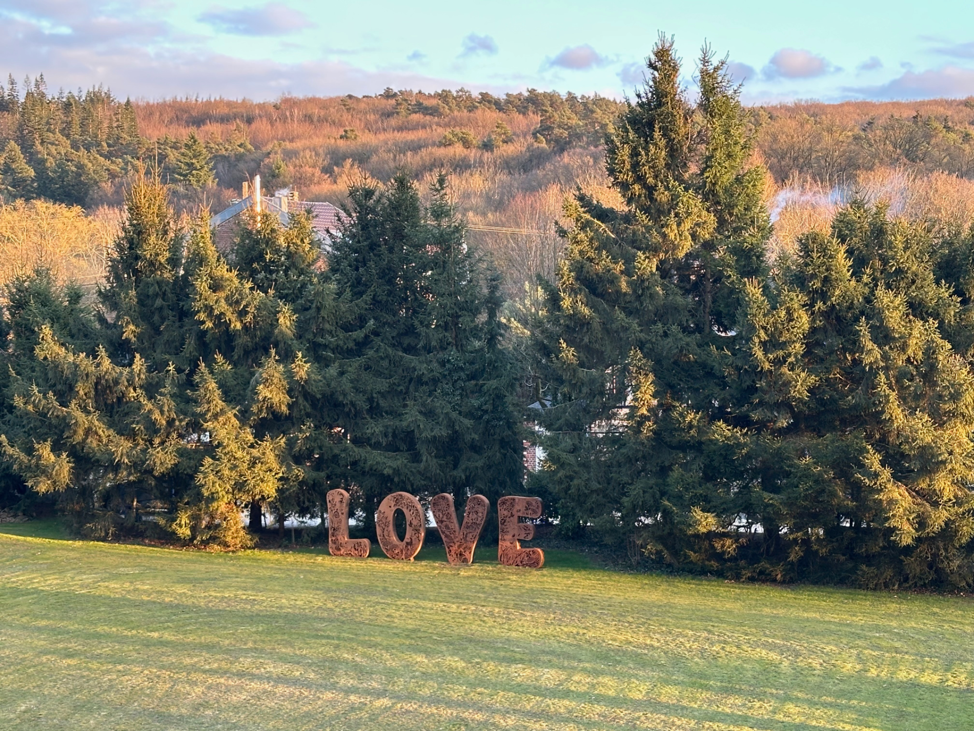 Das große LOVE-Zeichen im Garten bei Abendlicht mit Blick über die Wälder