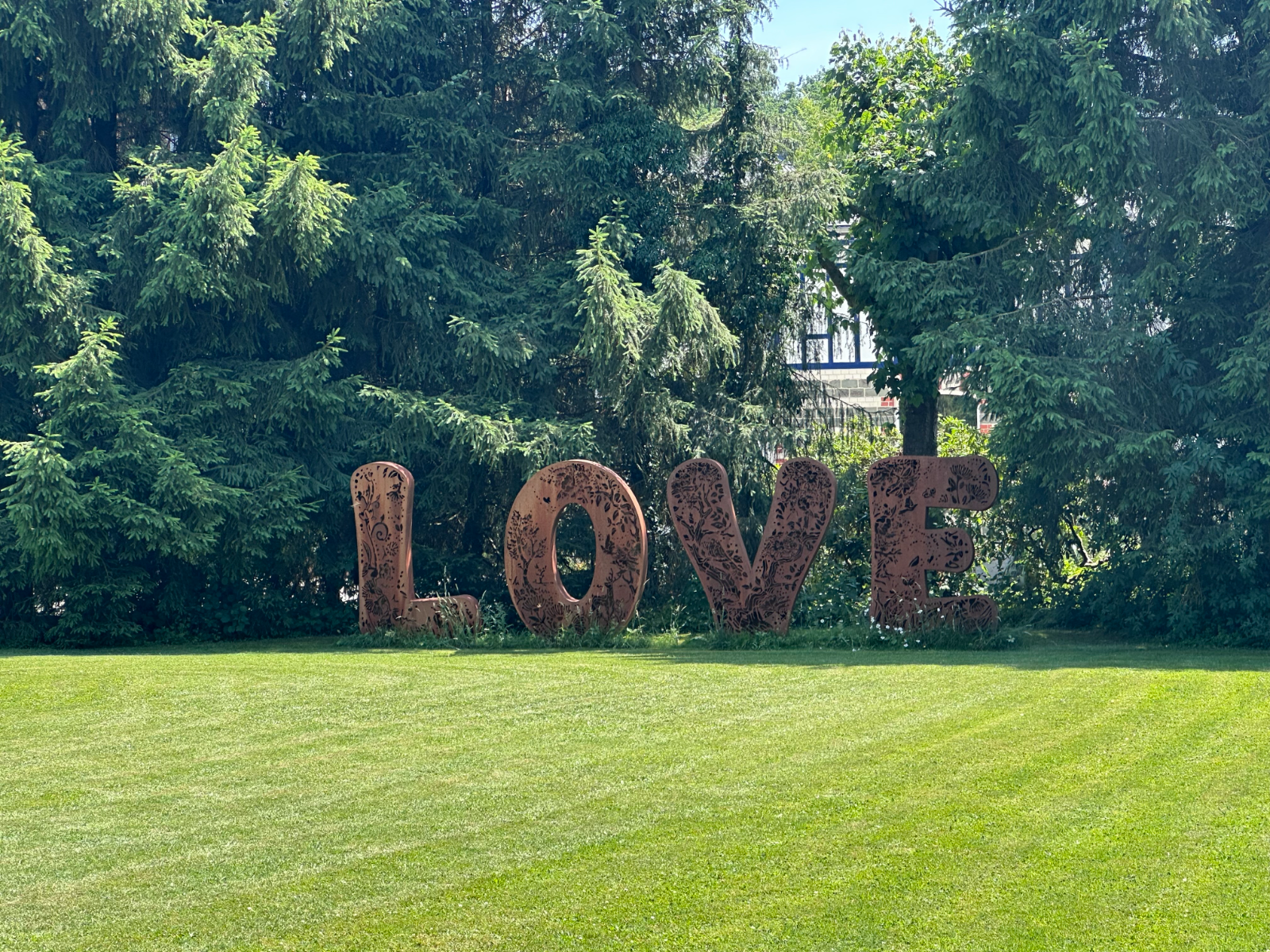 Das große LOVE-Zeichen aus Metall im sommerlichen Garten