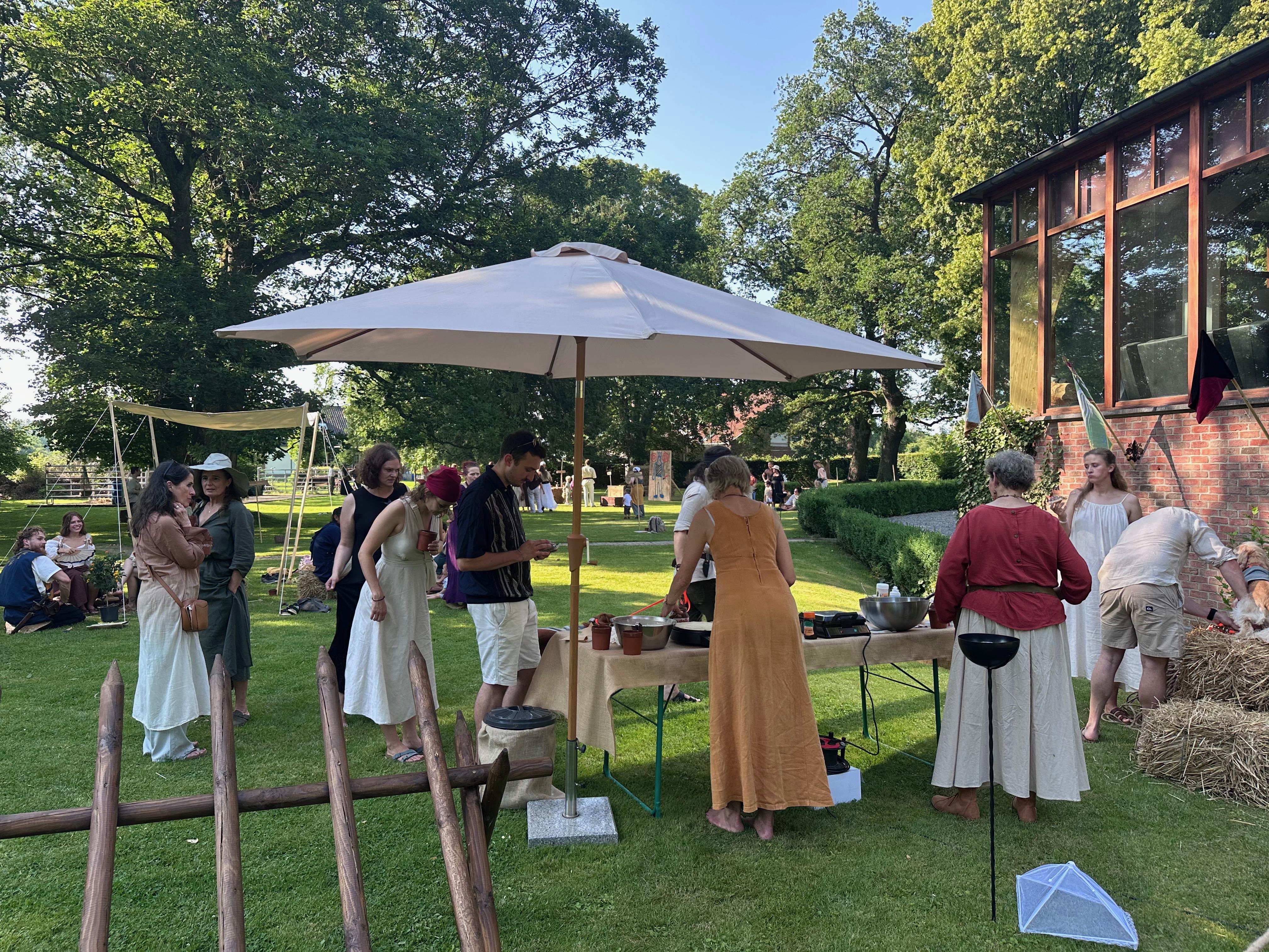 Geselliges Beisammensein unter Sonnenschirmen im Garten